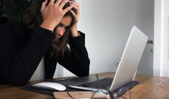Frustrated person sitting in front of a computer.