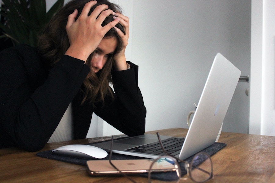 A frustrated person sitting in front of a computer.